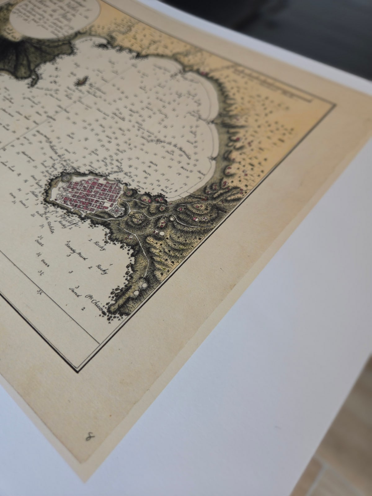 Una lámina de un mapa recién impresa, sobre la mesa, a la luz de la ventana