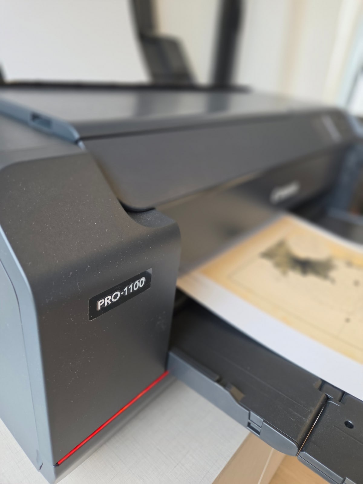 El costado de la impresora PRO-1100, con la hoja saliendo